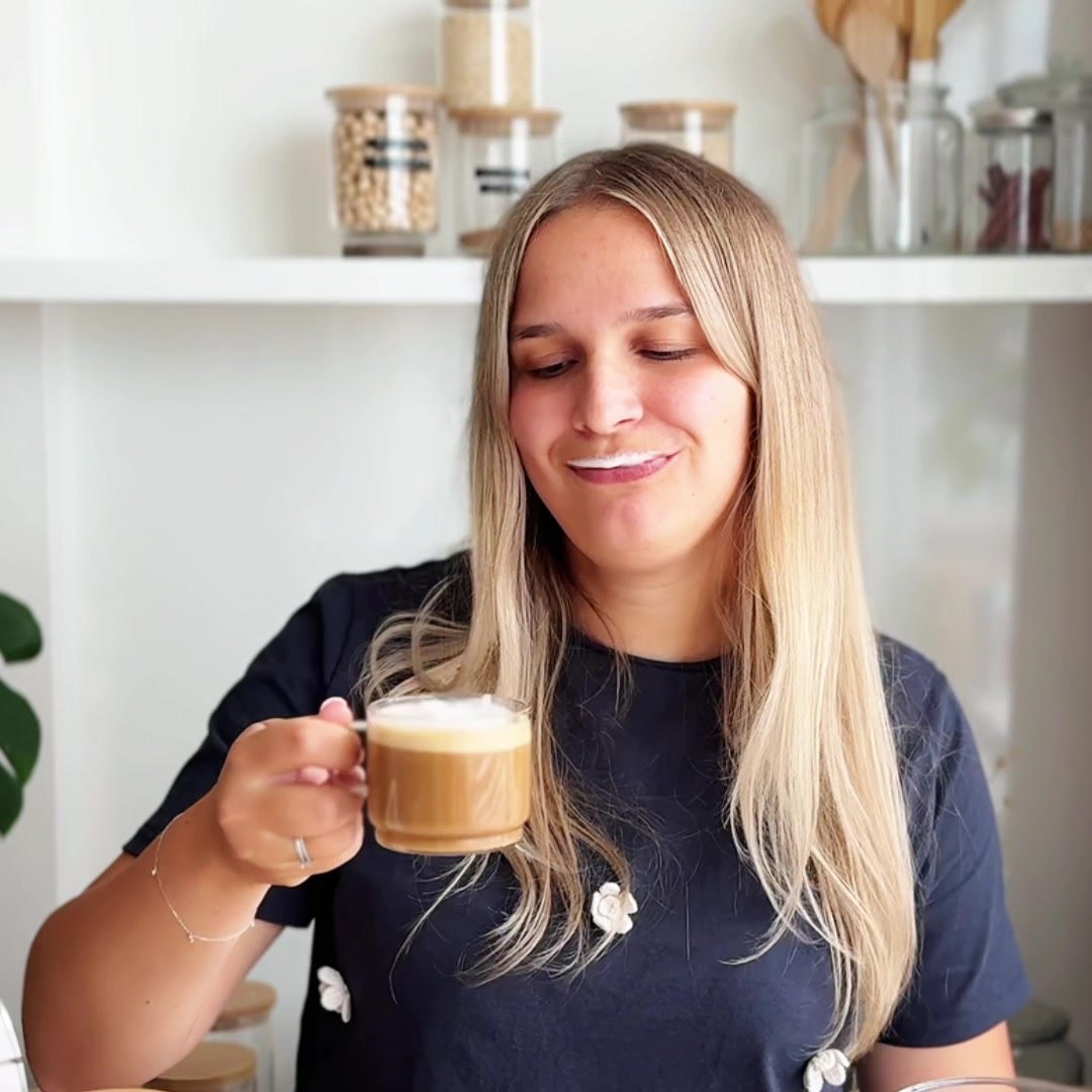 Woman smiling after the first sip of a latte made with fresh homemade soy milk
