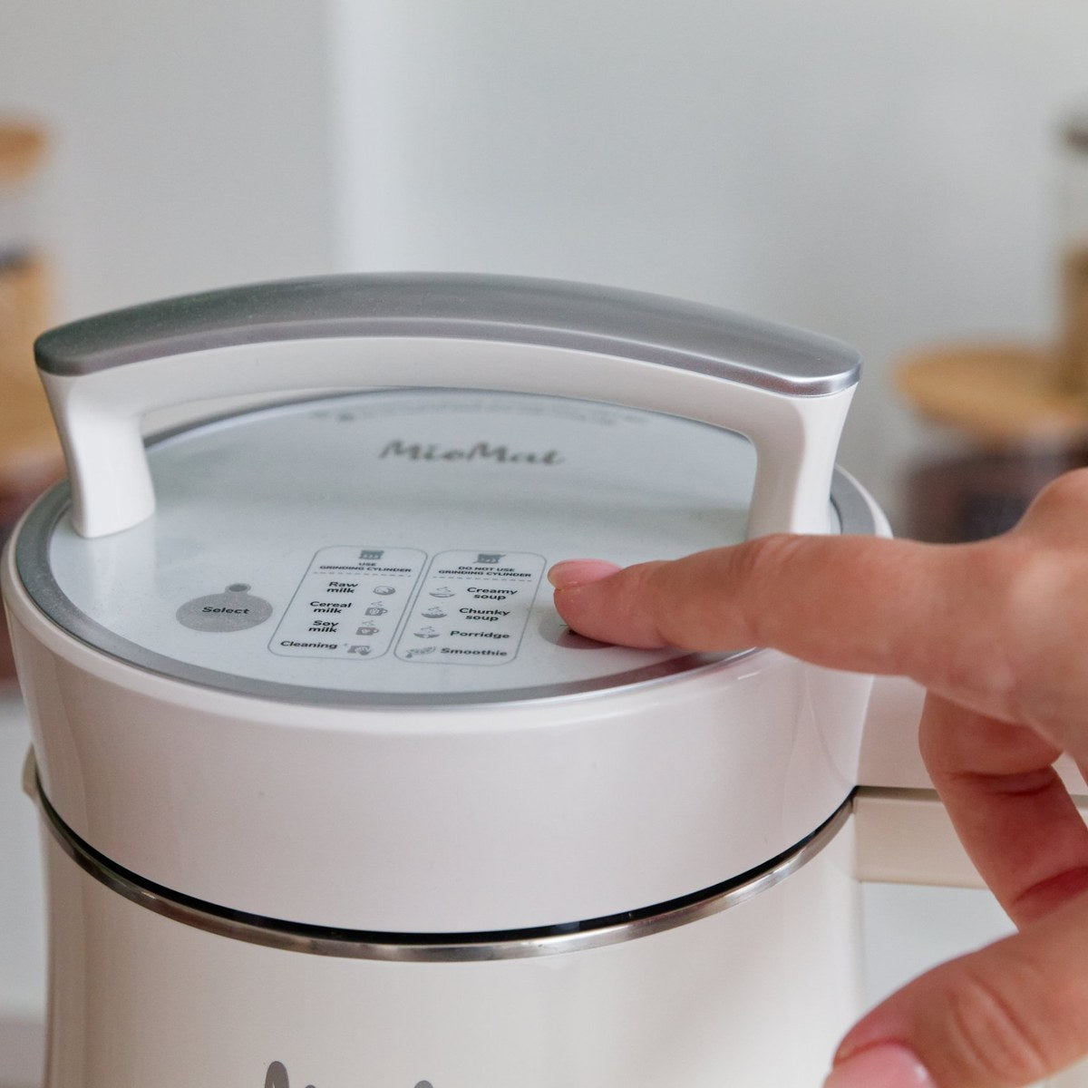Finger pressing the program button on the MioMat